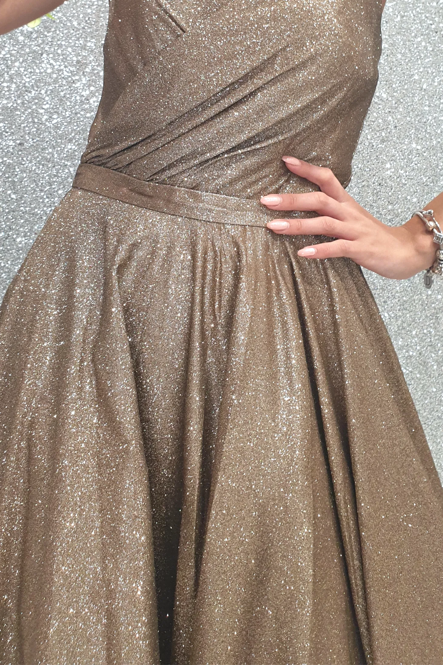 Abito svasato in tessuto glitterato dorato bronzo con corpetto cuore a punta e lunghezza asimmetrica