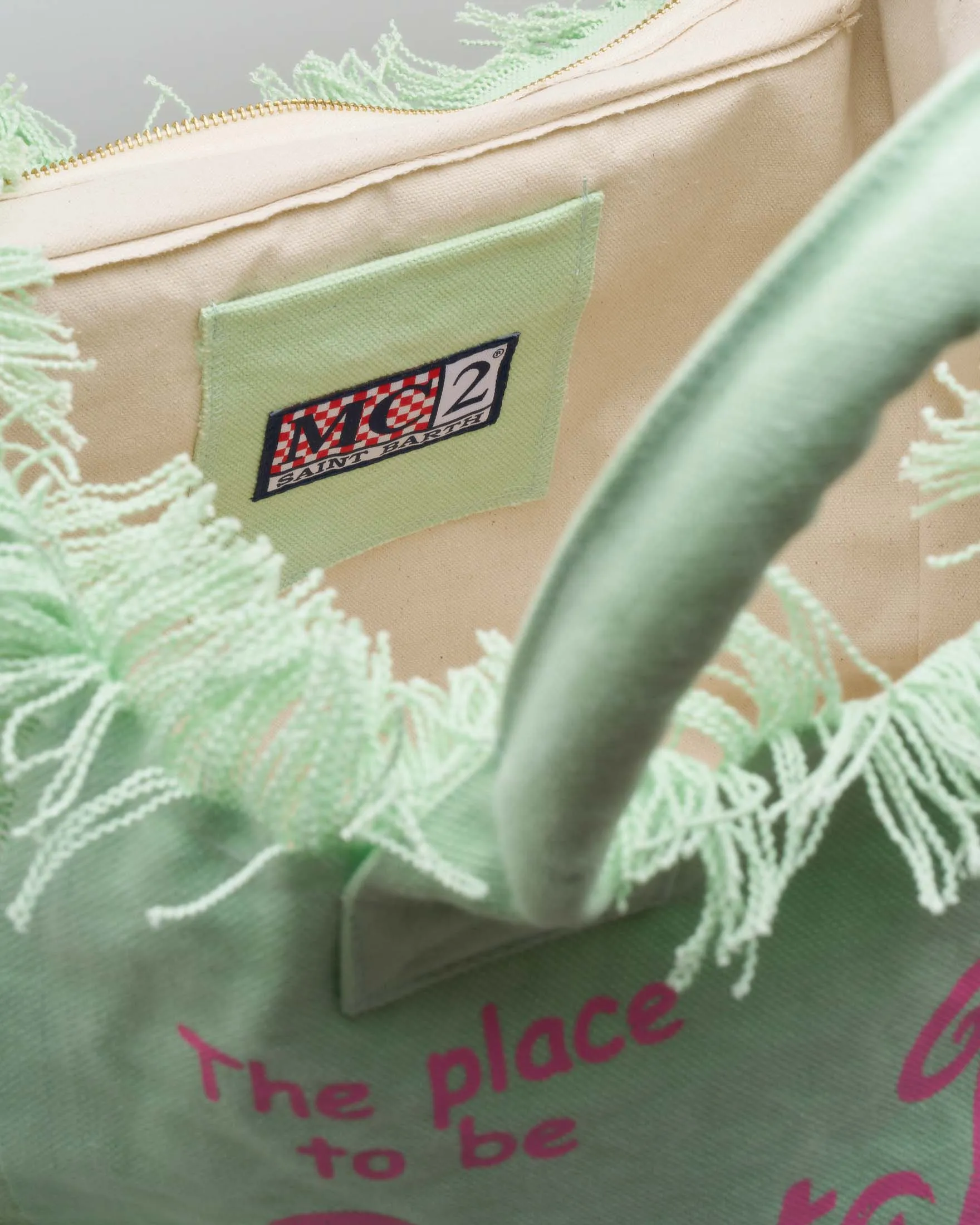 Borsa in canvas di cotone verde menta con scritta logo fucsia stampata e frange lungo i profili